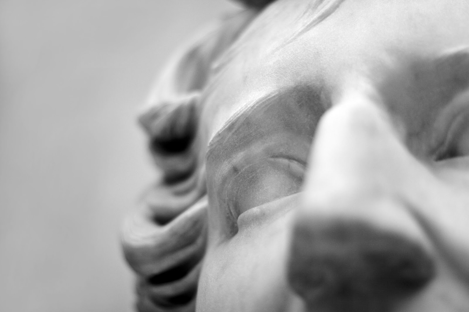Close-up black and white photo of a marble statue’s face, focusing on the eye, brow, and part of the nose and forehead, with soft details and wavy hair—an elegant tribute to stone preservation and timeless artistry.