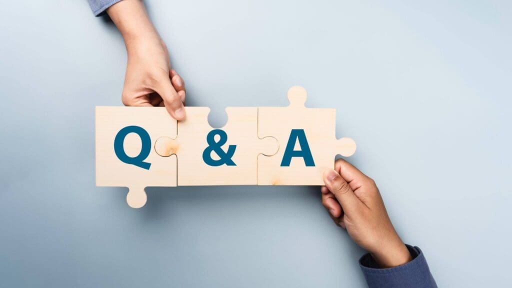Two hands connect three wooden puzzle pieces with the letters Q, &, and A printed on them, symbolizing collaboration and a question and answer concept—ideal for an architect or stone fabricator—against a light gray background.
